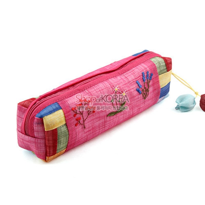 분홍 모시 원단에 다채로운 꽃자수와 끝부분 색동 배색, 끈 달린 복주머니 장식이 있는 필통. 분홍 모시 원단에 다채로운 꽃자수와 끝부분 색동 배색, 끈 달린 복주머니 장식이 있는 필통.