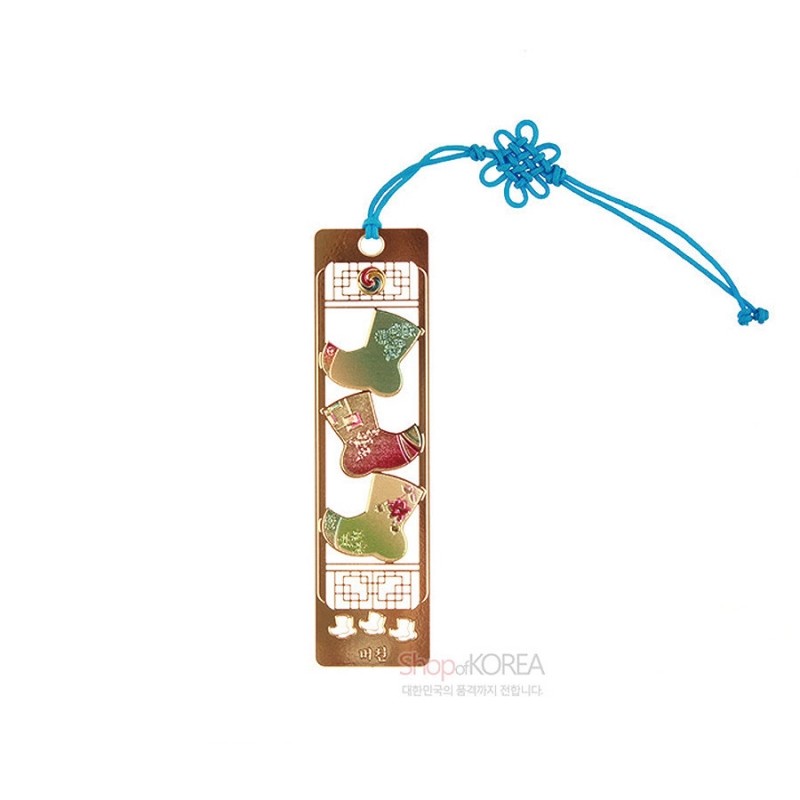 금장 금속 재질에 전통 버선 문양을 배치하고 청색 매듭 끈을 더한 책갈피.