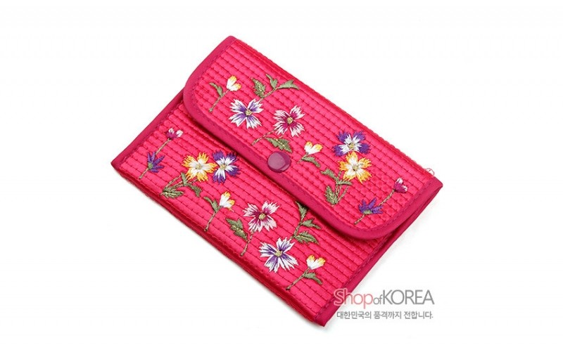 분홍색 누비 원단 위에 다채로운 꽃 자수 문양이 놓인 스냅 단추 여밈 동전지갑.