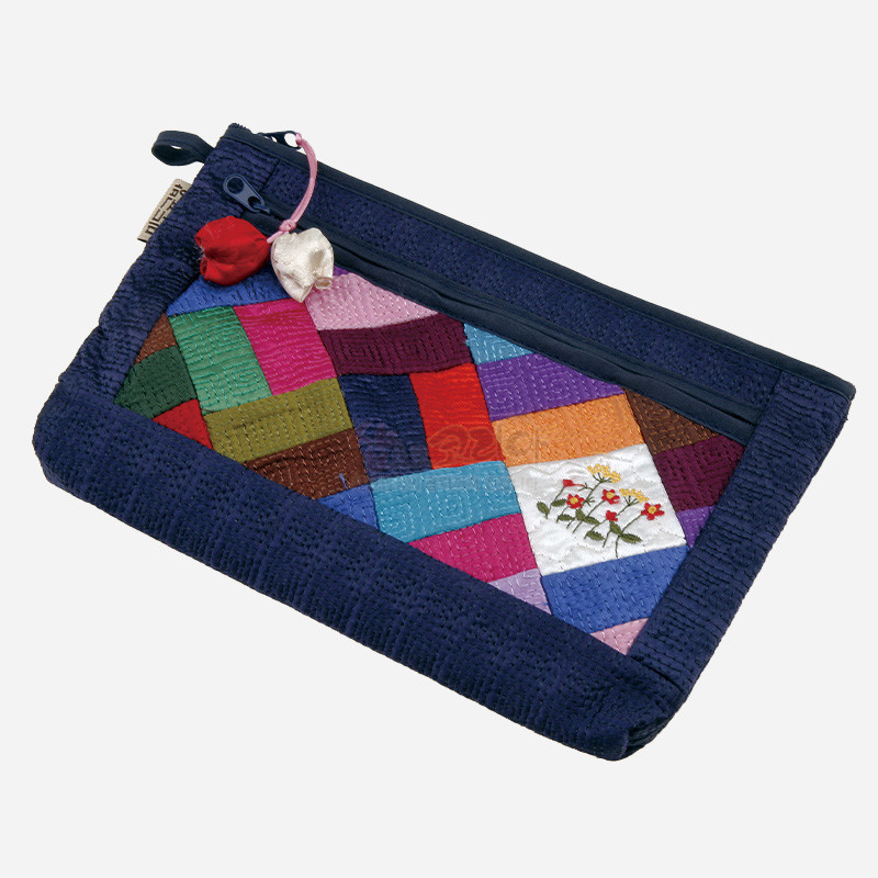 남색 누비 원단 테두리에 알록달록한 조각보 패치워크와 꽃 자수 문양이 조합된 지퍼 파우치.