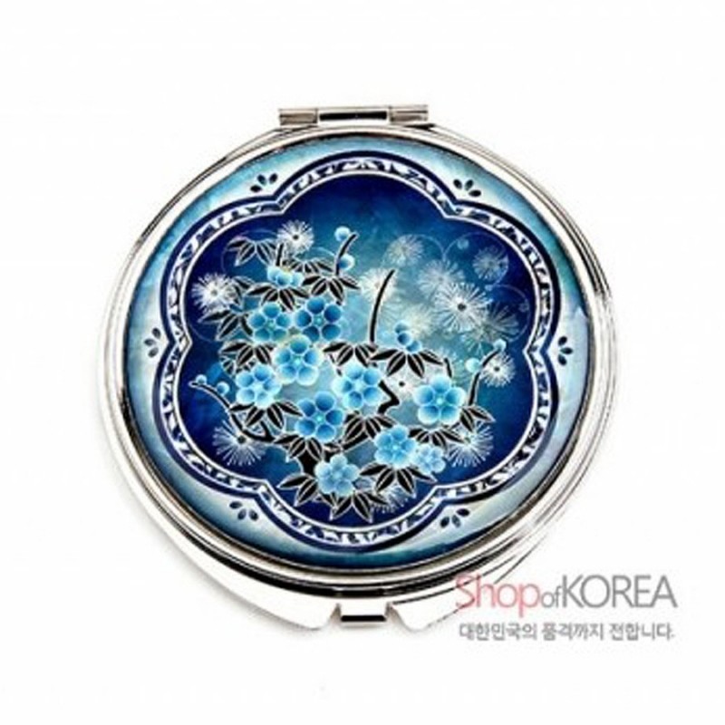 청색 그라데이션 배경 위 자개 상감 기법으로 매화와 민들레 문양을 표현한 원형 금속 손거울.