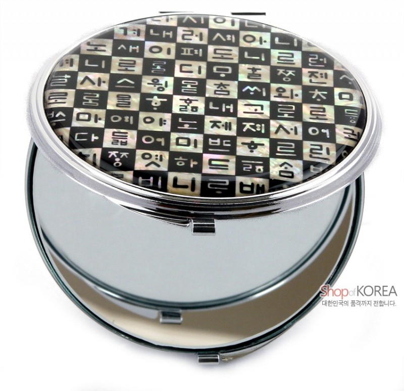 자개 상감 기법으로 훈민정음 한글 자모를 검은 바탕에 배열한 원형 금속 손거울. 자개 상감 기법으로 훈민정음 한글 자모를 검은 바탕에 배열한 원형 금속 손거울.