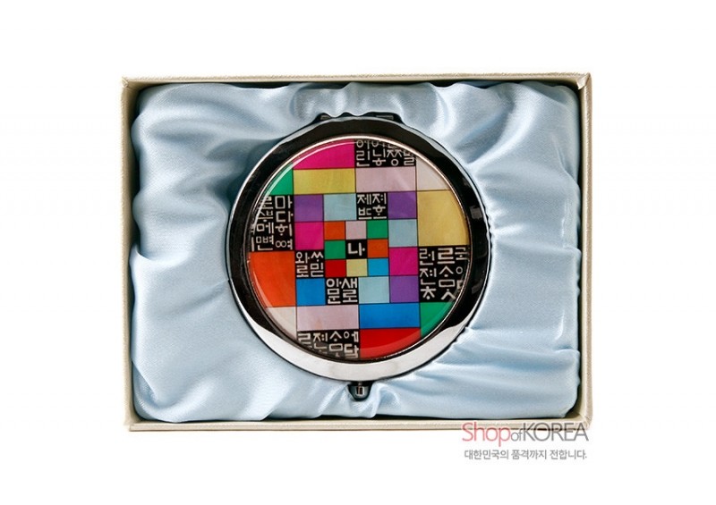 금속 테두리에 자개 장식이 더해지고, 다채로운 조각보 색상과 훈민정음 글자 배열이 특징인 원터치 손거울.