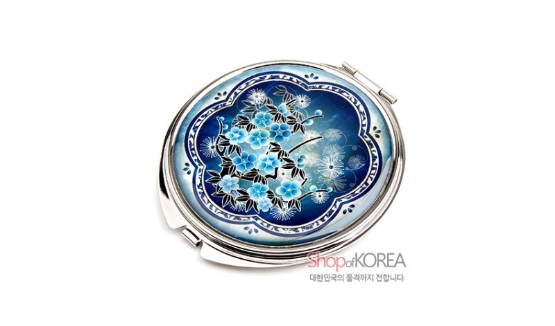 청색 그라데이션 바탕에 자개 상감 기법으로 매화와 국화 문양을 표현한 금속 테두리 손거울.