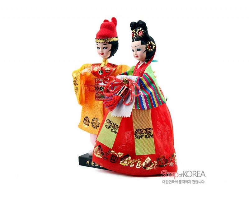 비단 느낌의 원단으로 제작된 왕과 비 인형, 금박 꽃문양과 채색 줄무늬 저고리, 매듭 장식 대롱노리개가 특징인 전통한복 장식 인형.