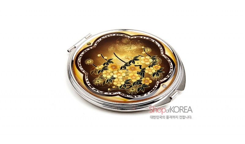 노란색과 갈색 배경 위 자개 상감 기법으로 매화 문양을 그린 원형 금속 손거울. 노란색과 갈색 배경 위 자개 상감 기법으로 매화 문양을 그린 원형 금속 손거울.