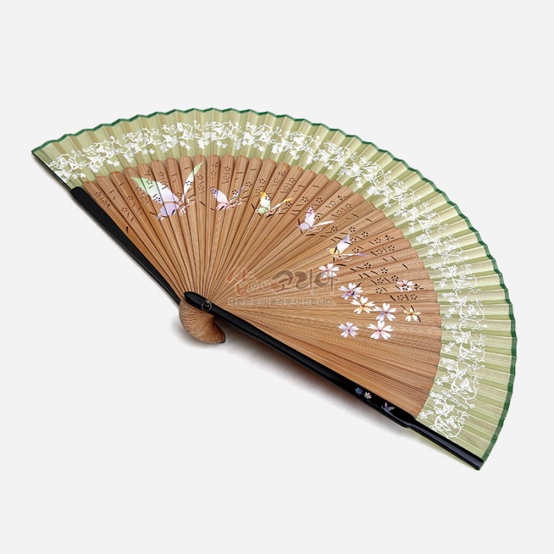 연녹색 실크 부채살에 나비·꽃 자개 장식과 한글 서예, 대나무 살의 천공 문양이 어우러진 전통 수공 부채. 연녹색 실크 부채살에 나비·꽃 자개 장식과 한글 서예, 대나무 살의 천공 문양이 어우러진 전통 수공 부채.