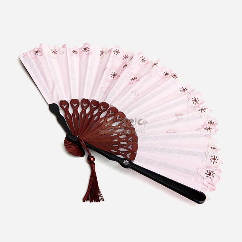 연분홍 비단 부채살에 매화 자수와 레이스 가장자리 장식, 나뭇결 무늬 살대와 자개 장식, 붉은 매듭 술이 어우러진 접선.