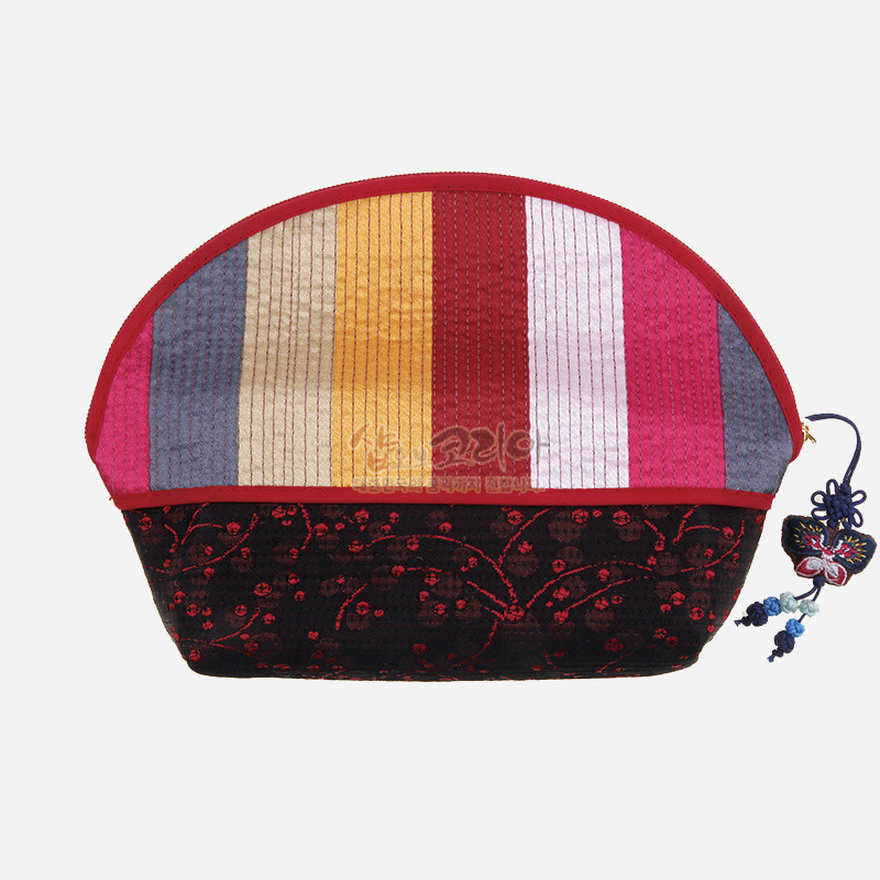 색동 누비 기법으로 구성된 반원형 파우치와 검은 바탕 붉은 자수 꽃무늬, 나비 모양 전통 매듭 장식이 달린 손지갑.