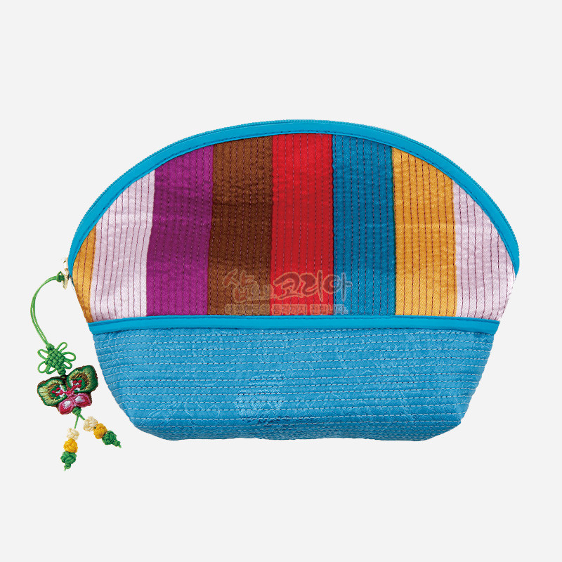 색동 비단 누비 기법으로 제작된 반월형 파우치, 청색 바탕과 다채로운 세로 색동단, 매듭 장식 달린 지퍼 손잡이가 특징인 손지갑.