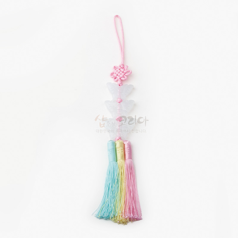 분홍색 매듭과 반투명 나비 장식, 하늘색·연두색·분홍색 실로 된 3단 술이 조화된 전통 노리개.