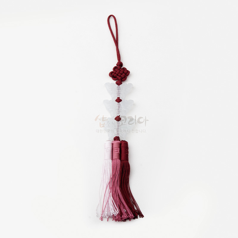 붉은 실 매듭에 반투명 나비 장식 3개가 연결되고, 분홍·자홍 그라데이션 비단 술 3가닥이 달린 전통 노리개.