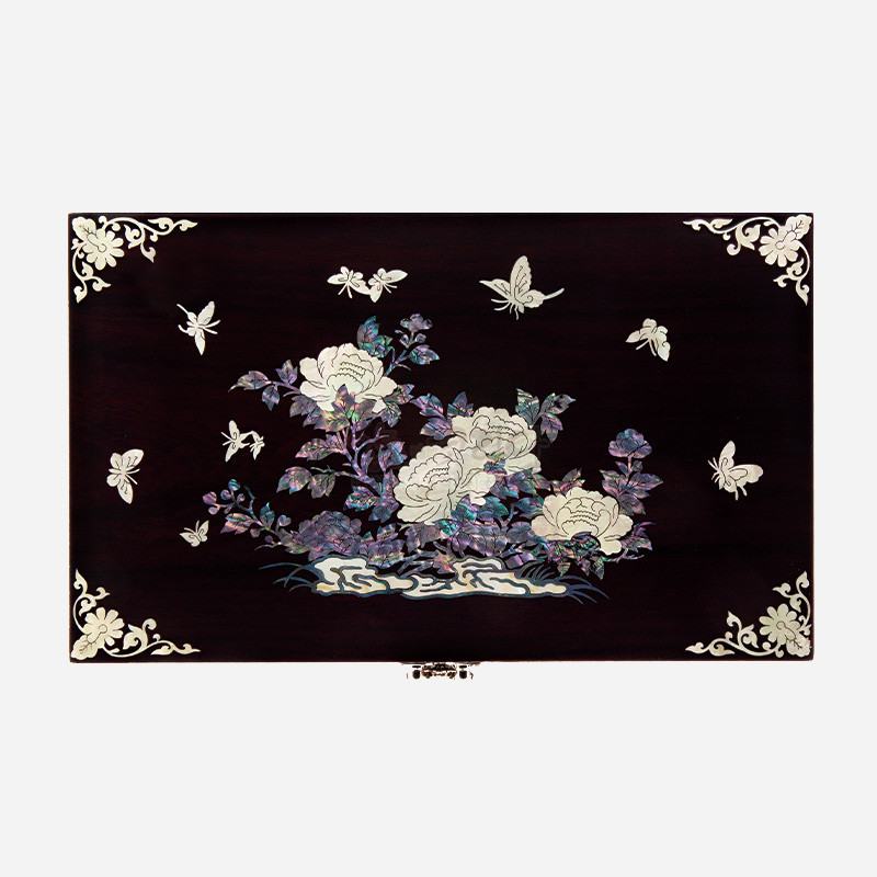 자개 상감 기법으로 목단과 나비 문양을 표현한 짙은 갈색 옻칠 나무 보석함. 자개 상감 기법으로 목단과 나비 문양을 표현한 짙은 갈색 옻칠 나무 보석함.