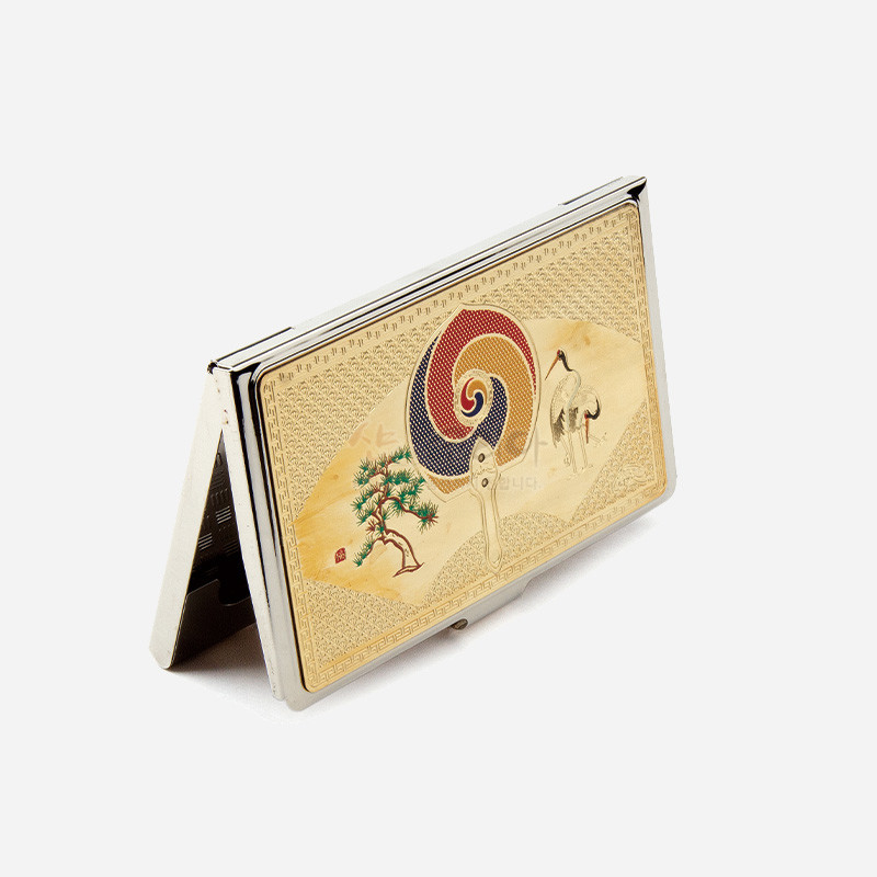 금속 재질 위 금장 처리된 표면에 태극 부채 문양과 소나무, 학이 섬세하게 채색된 전통 문양 장식 명함케이스.