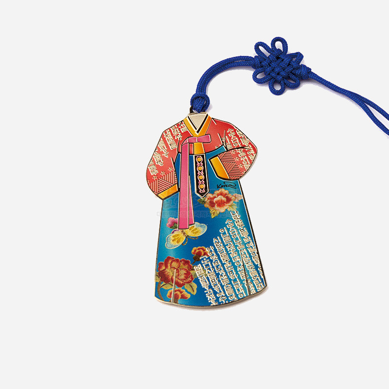 금속 재질에 채색 기법을 적용한 한복 모양 책갈피, 청색과 적색 바탕에 꽃문양과 한글 문자 패턴, 청색 매듭 끈 장식.