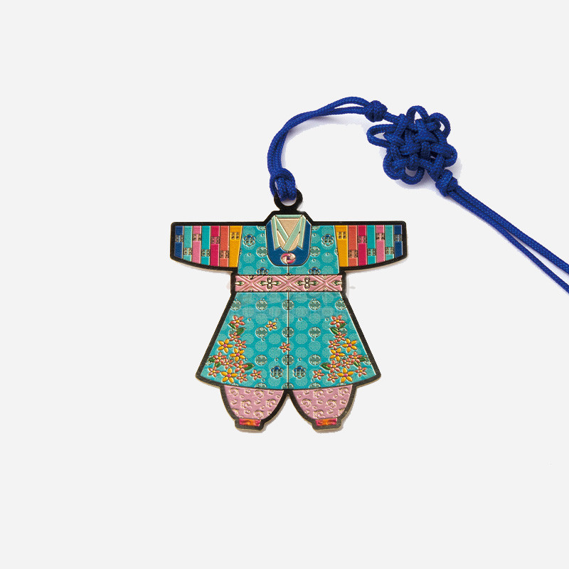 금속 재질에 채색 기법을 더한 아동 색동한복 형상의 책갈피, 화려한 꽃문양과 파스텔 색상, 청색 매듭끈 장식.
