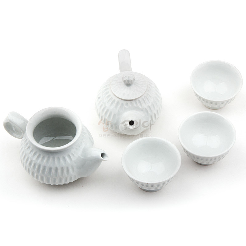 백자 재질의 흰색 다기 세트로, 표면 전체에 정교한 빗살무늬 음각이 들어간 찻주전자와 찻잔 구성이 특징인 디자인. 백자 재질의 흰색 다기 세트로, 표면 전체에 정교한 빗살무늬 음각이 들어간 찻주전자와 찻잔 구성이 특징인 디자인.