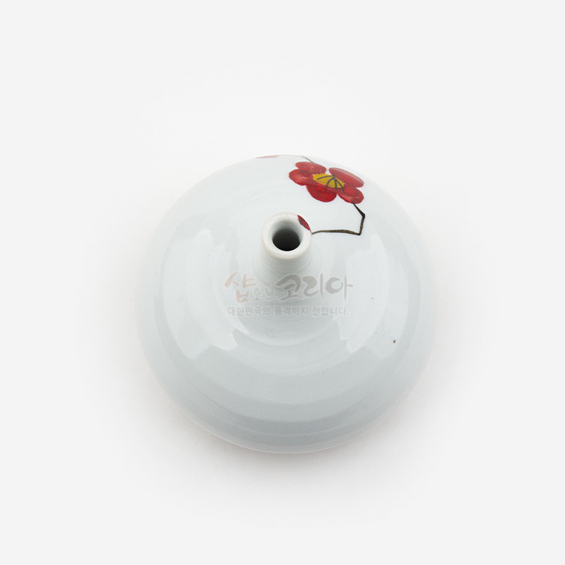백자 재질의 둥근 화병에 붉은 매화꽃과 가지를 단순화해 그린 회화적 문양 장식. 백자 재질의 둥근 화병에 붉은 매화꽃과 가지를 단순화해 그린 회화적 문양 장식.