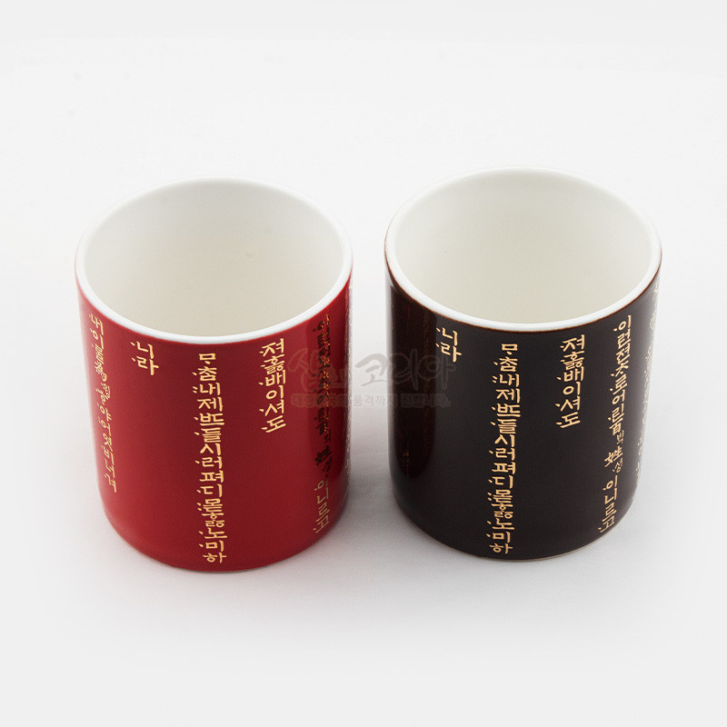 빨강·검정 유약 도자기 표면에 황금색 훈민정음 서체를 세로 배열로 장식한 머그컵 세트.