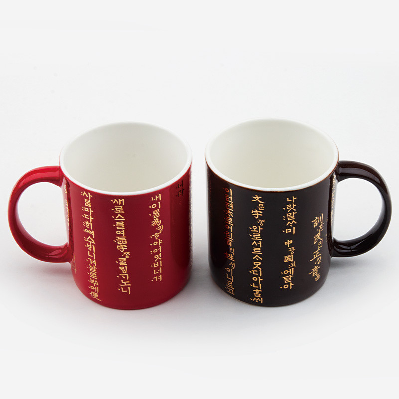 붉은색·검은색 유약 처리 도자 재질에 금색 훈민정음 서체가 둘레를 감싸 장식된 머그컵 세트.