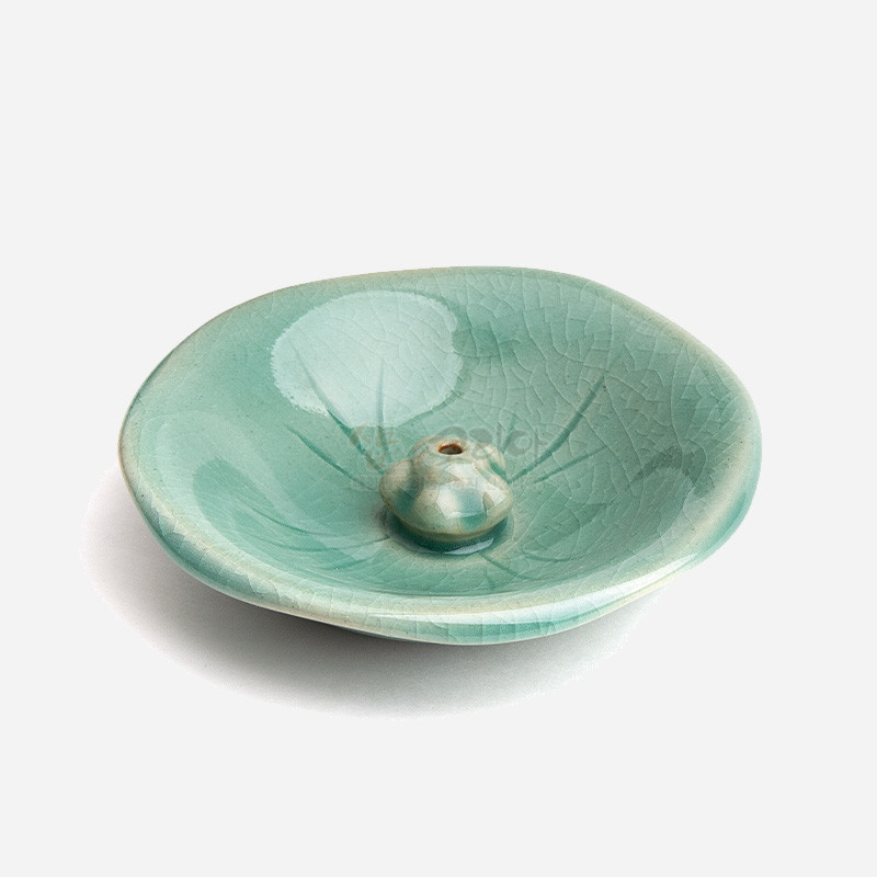 비취색 유약을 입힌 도자 재질, 연잎 잎맥 문양과 중앙 연꽃봉오리 형상의 향꽂이 접시. 비취색 유약을 입힌 도자 재질, 연잎 잎맥 문양과 중앙 연꽃봉오리 형상의 향꽂이 접시.