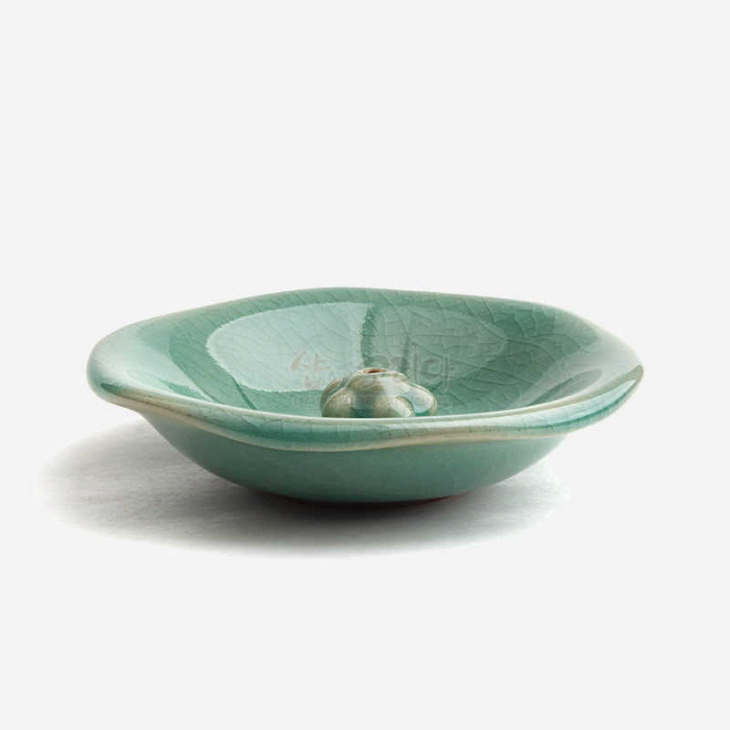 청자 재질의 연잎 형상 향꽂이 접시, 잎맥을 살린 음각 문양과 유약의 자연스러운 균열무늬가 특징인 공예품. 청자 재질의 연잎 형상 향꽂이 접시, 잎맥을 살린 음각 문양과 유약의 자연스러운 균열무늬가 특징인 공예품.