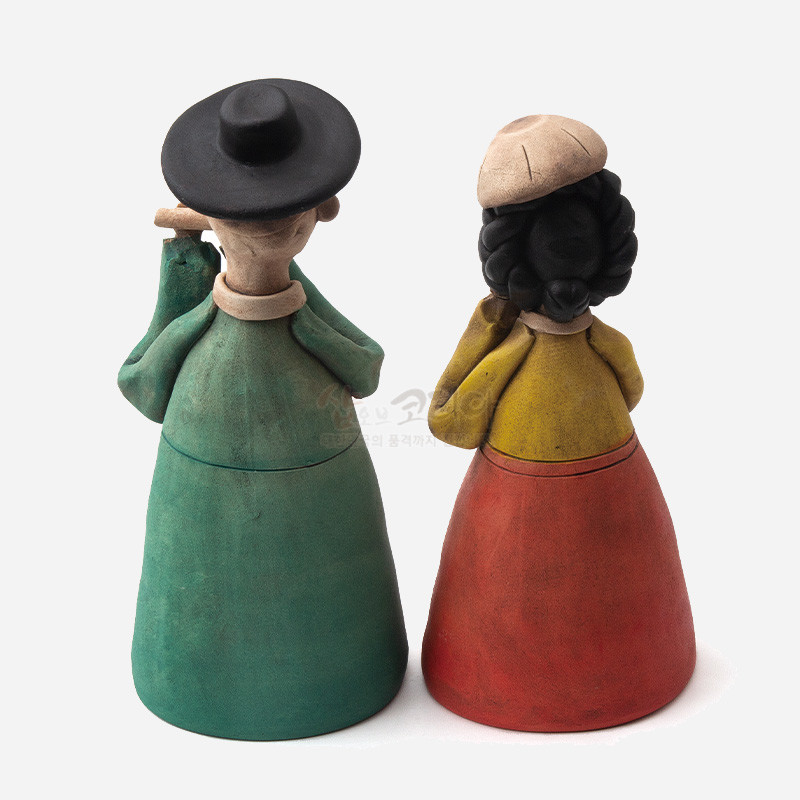 황토 재질로 빚은 선비와 여인 인형, 녹색·적색 의상과 검은 상투 머리, 소박한 민속풍 색채가 특징인 장식 인형.