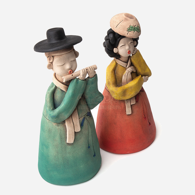 황토 재질로 빚은 선비와 여인 인형, 청록·적색 한복과 노랑 저고리의 배색, 단순화된 얼굴과 소박한 질감이 특징인 장식 인형.