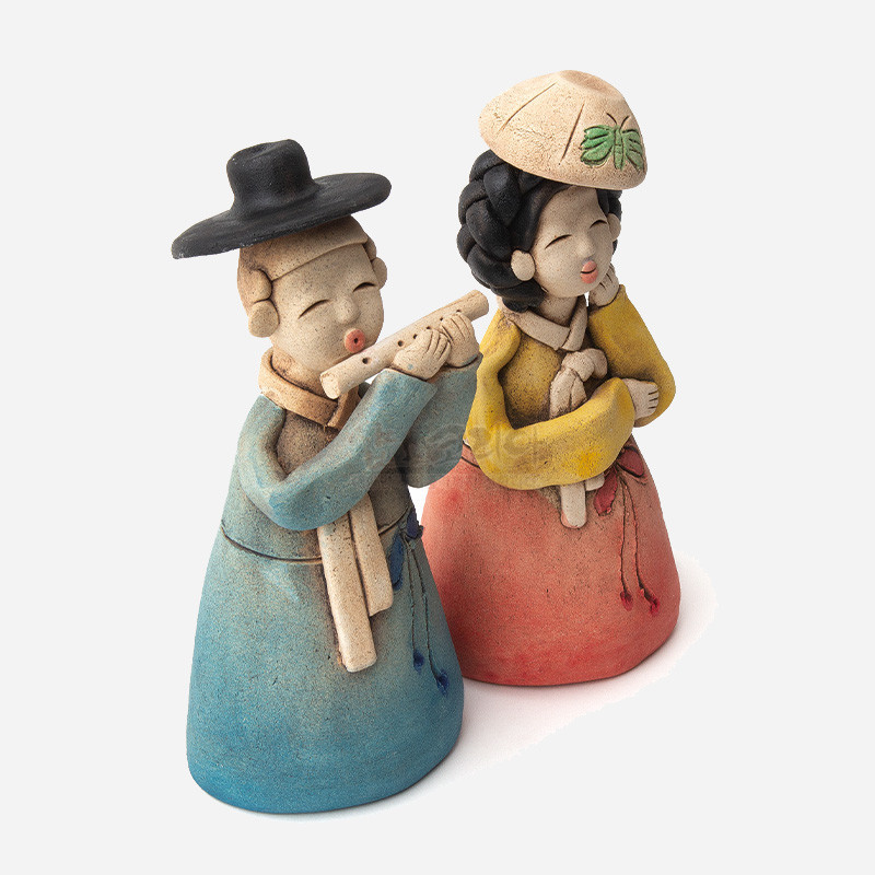 황토 재질로 빚은 선비와 기생 인형, 파스텔톤 청·홍색 한복과 모자에 새긴 장수문 패턴이 특징인 조형 장식. 황토 재질로 빚은 선비와 기생 인형, 파스텔톤 청·홍색 한복과 모자에 새긴 장수문 패턴이 특징인 조형 장식.