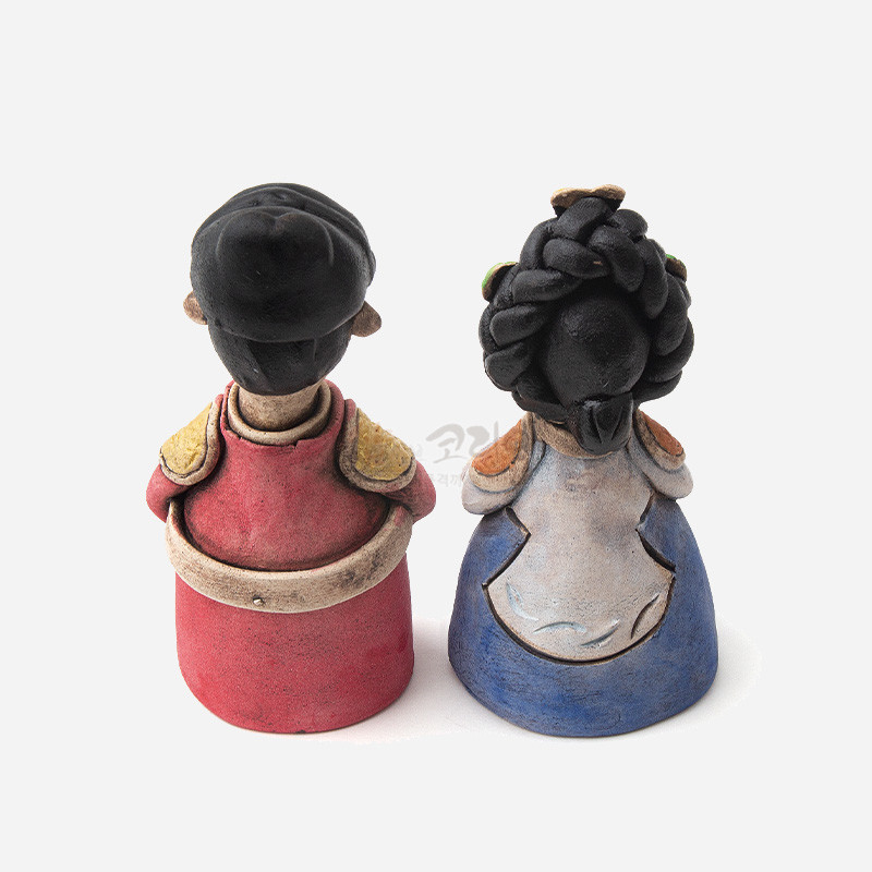 채색 도자 재질로 표현한 작은 왕과 왕비 인형, 붉은색·청색 한복과 전통 머리형, 단순 곡선 문양 장식.