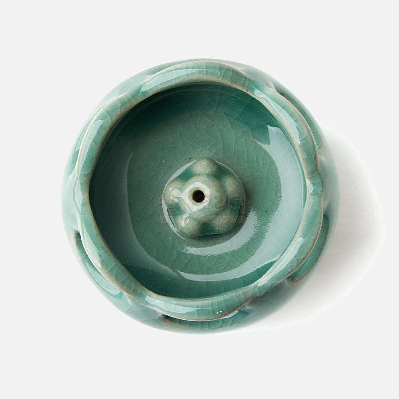 청자빛 유약이 입혀진 도자 재질의 작은 향꽂이, 균열무늬와 연잎 형상의 투각 장식이 특징인 디자인. 청자빛 유약이 입혀진 도자 재질의 작은 향꽂이, 균열무늬와 연잎 형상의 투각 장식이 특징인 디자인.