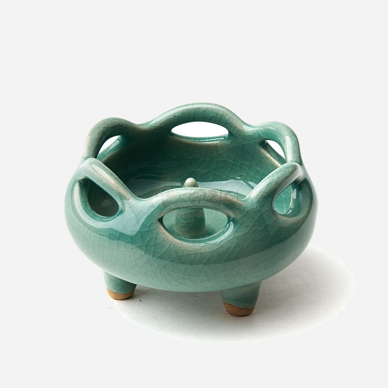 청자빛 유약과 은은한 균열무늬가 특징인 투각 손잡이와 세 발 구조의 도자 촛대. 청자빛 유약과 은은한 균열무늬가 특징인 투각 손잡이와 세 발 구조의 도자 촛대.