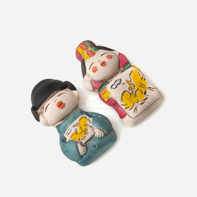 황토 느낌의 도자 재질로 빚은 신랑신부 형상 자석, 가슴 부분 노란 나비문과 청록·홍색 등 선명한 채색이 특징인 냉장고 장식. 황토 느낌의 도자 재질로 빚은 신랑신부 형상 자석, 가슴 부분 노란 나비문과 청록·홍색 등 선명한 채색이 특징인 냉장고 장식.