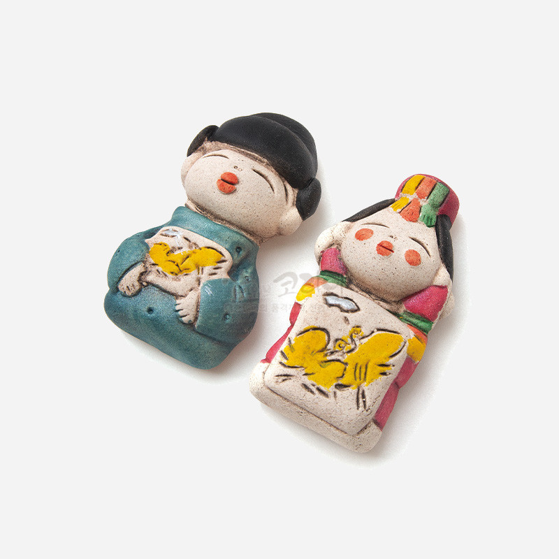 황토빛 도자 재질에 청록·분홍 색동 혼례복과 노랑 봉황 문양을 채색한 신랑신부 형상의 냉장고 자석. 황토빛 도자 재질에 청록·분홍 색동 혼례복과 노랑 봉황 문양을 채색한 신랑신부 형상의 냉장고 자석.