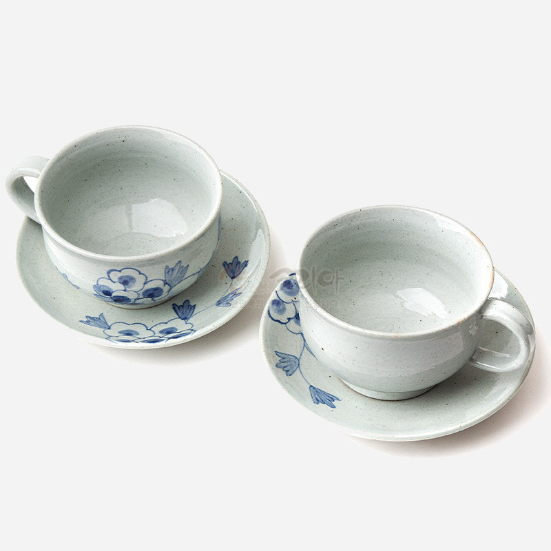 분청사기 재질의 커피잔과 받침 세트, 흐린 회백색 유약에 청색 목단 꽃문양이 수묵화풍으로 장식된 구성. 분청사기 재질의 커피잔과 받침 세트, 흐린 회백색 유약에 청색 목단 꽃문양이 수묵화풍으로 장식된 구성.