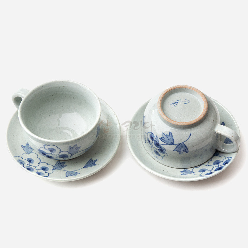분청도자 재질의 커피잔과 받침 세트, 청화 기법으로 표현된 목단 꽃문양과 은은한 회백색 유약이 특징인 구성. 분청도자 재질의 커피잔과 받침 세트, 청화 기법으로 표현된 목단 꽃문양과 은은한 회백색 유약이 특징인 구성.