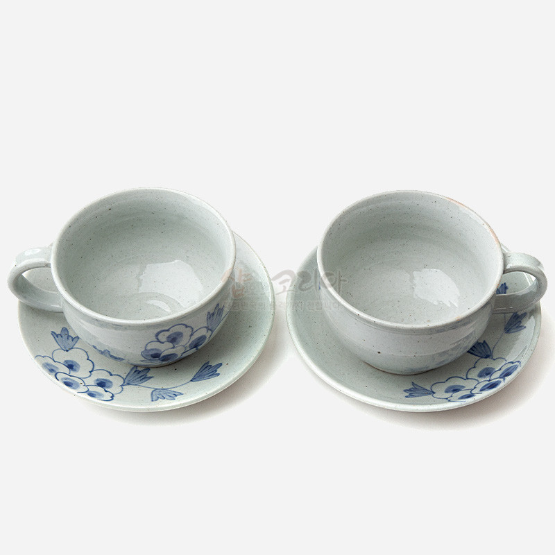 분청사기 재질의 커피잔과 받침 세트, 회백색 바탕에 청색 목단 꽃문양이 그려진 전통 도자기 디자인. 분청사기 재질의 커피잔과 받침 세트, 회백색 바탕에 청색 목단 꽃문양이 그려진 전통 도자기 디자인.