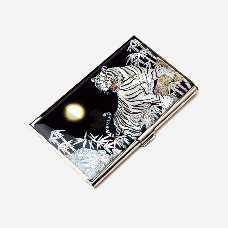 흑색 옻칠 바탕에 자개 상감 기법으로 백호와 대나무, 달 문양을 표현한 금속 명함집.