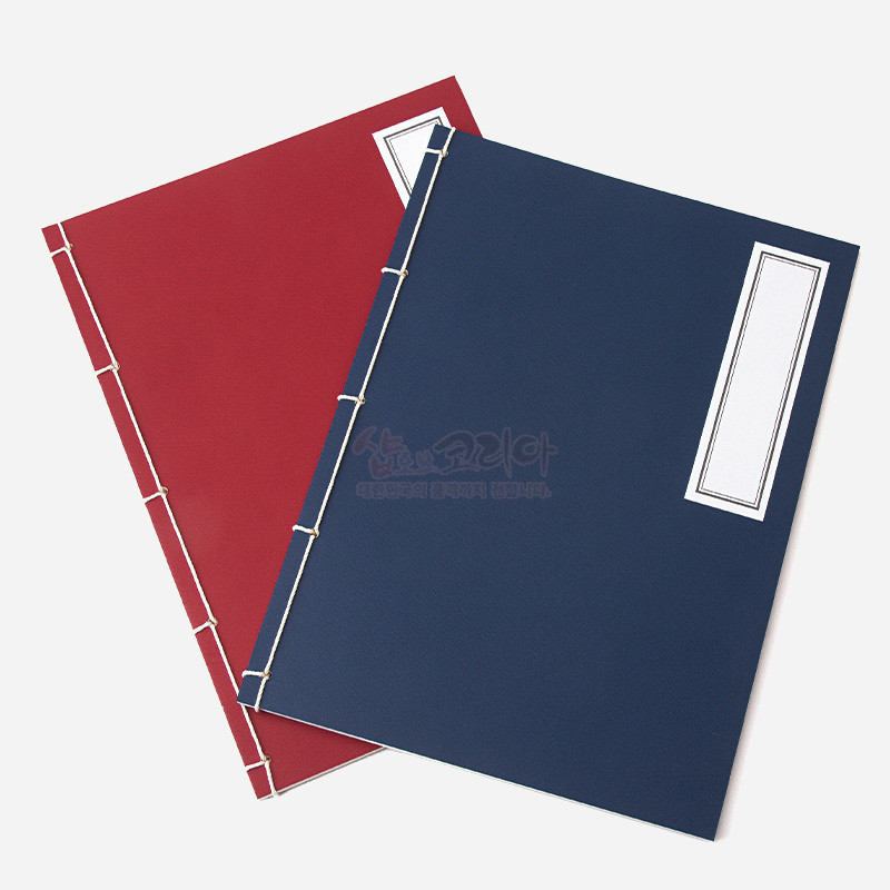 붉은색과 남색 표지 위 흰 실로 제본한 전통 오침 방식 노트, 직사각형 라벨 장식 특징.