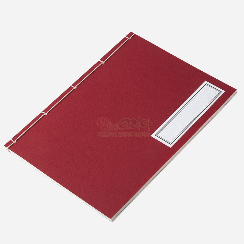 적색 종이 표지에 흰색 실로 전통 오침 제본한 노트, 우측 직사각형 라벨 장식이 특징인 문구류.