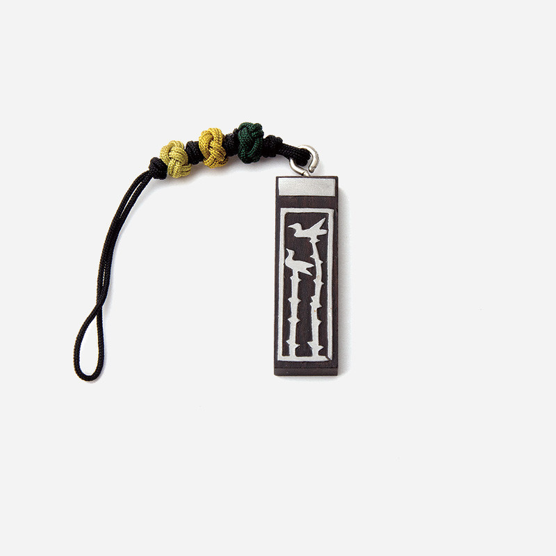 흑단 소재 직사각 패endant에 새와 솟대 문양 상감 장식, 노랑·연두 매듭 끈 장식 열쇠고리.