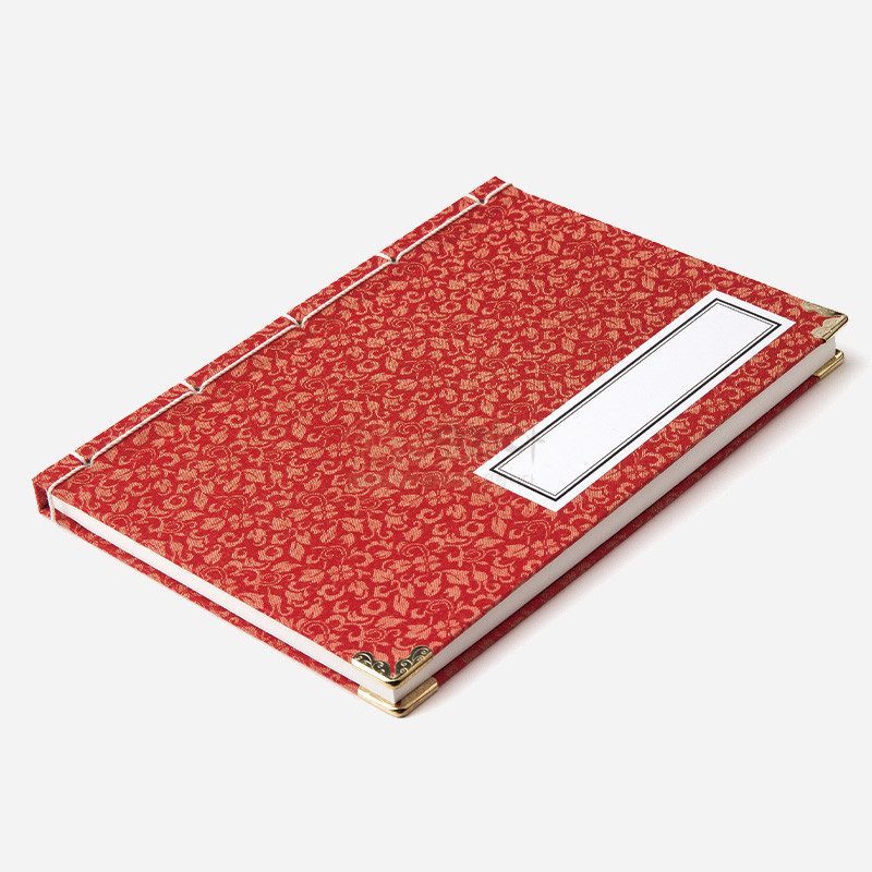 붉은 비단에 금색 전통 무늬를 더한 표지와 금속 모서리 장식, 흰색 끈 오침 제본이 특징인 노트. 붉은 비단에 금색 전통 무늬를 더한 표지와 금속 모서리 장식, 흰색 끈 오침 제본이 특징인 노트.