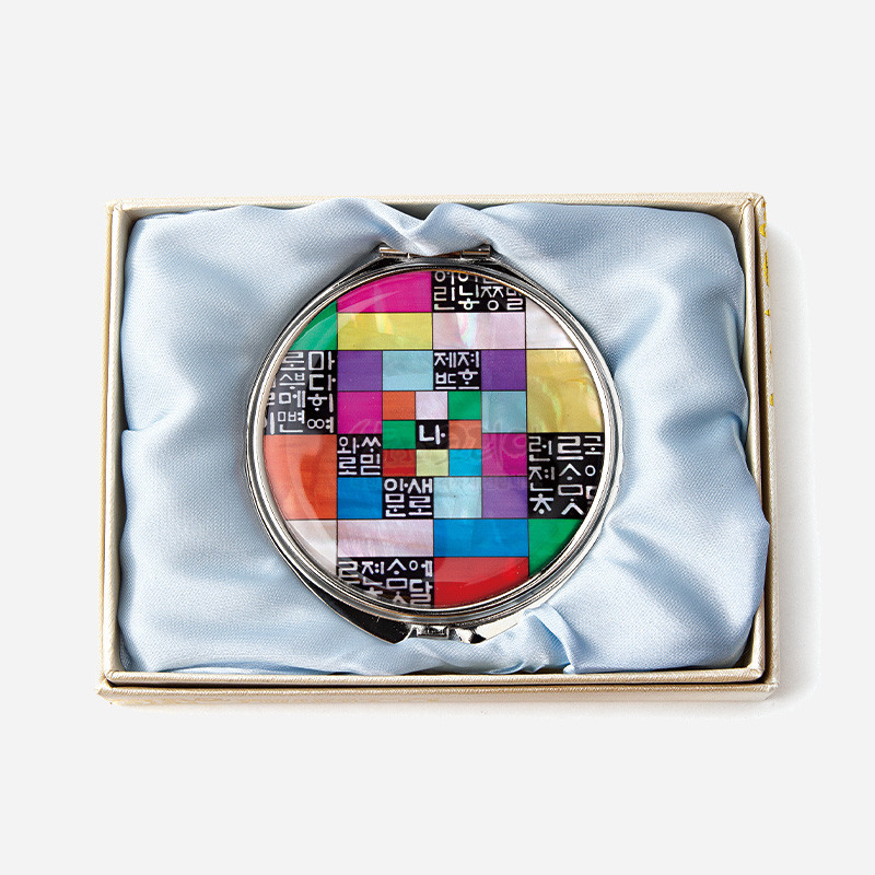 자개 상감 기법으로 표현한 오색 조각보와 흑백 훈민정음 글자 무늬가 특징인 금속 손거울.