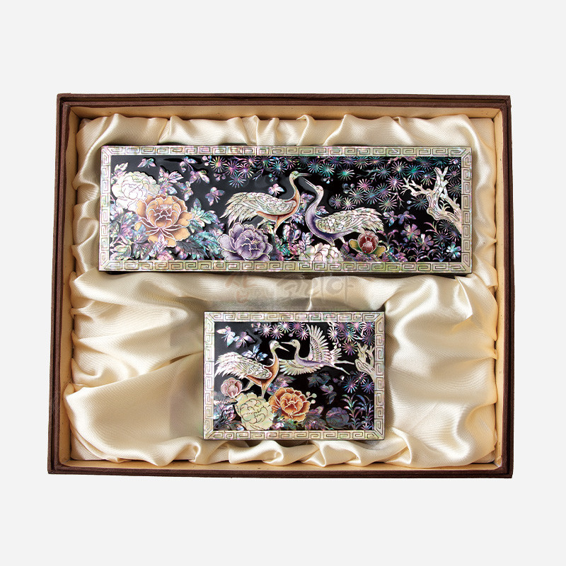 흑색 옻칠 바탕에 자개 상감 기법으로 송학과 모란, 국화 문양을 화려한 오방색 계열로 표현한 직사각형 필함·명함함 세트.