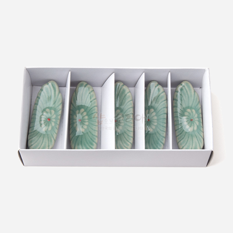 연한 청록색 유약을 입힌 도자 재질, 중앙에 붉은 점이 있는 꽃무늬가 새겨진 타원형 수저받침 5종 세트. 연한 청록색 유약을 입힌 도자 재질, 중앙에 붉은 점이 있는 꽃무늬가 새겨진 타원형 수저받침 5종 세트.