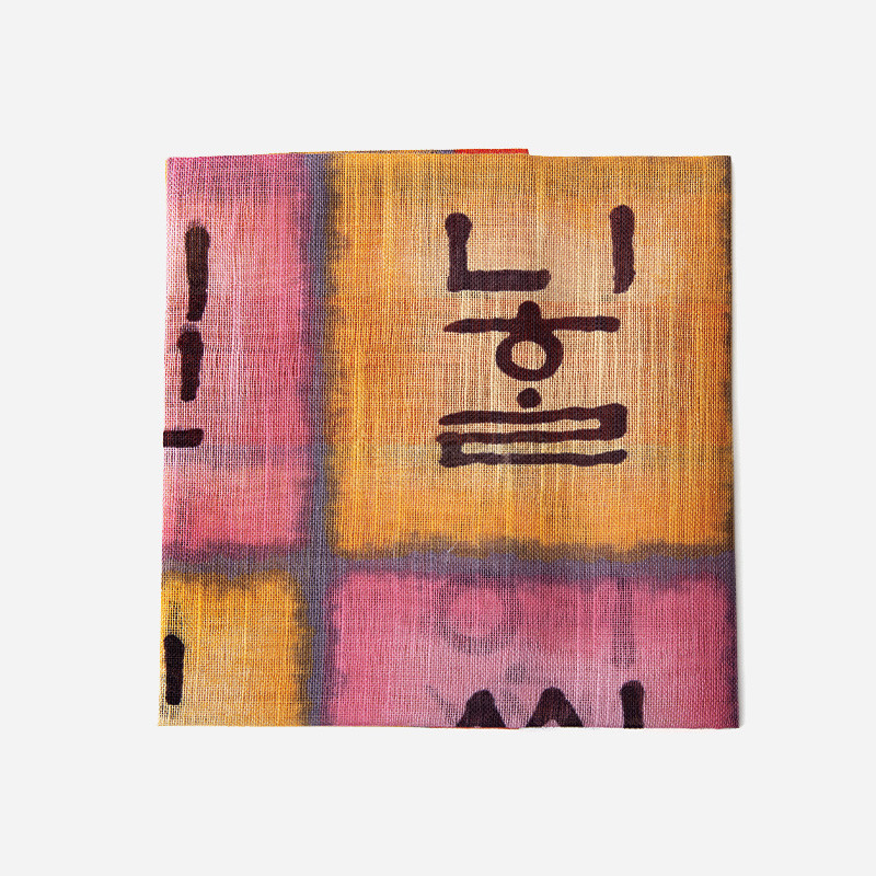 훈민정음 글자를 모티프로 한글 서체 문양이 인쇄된 면 소재 손수건, 분홍·노랑 그라데이션 배색이 특징인 디자인.