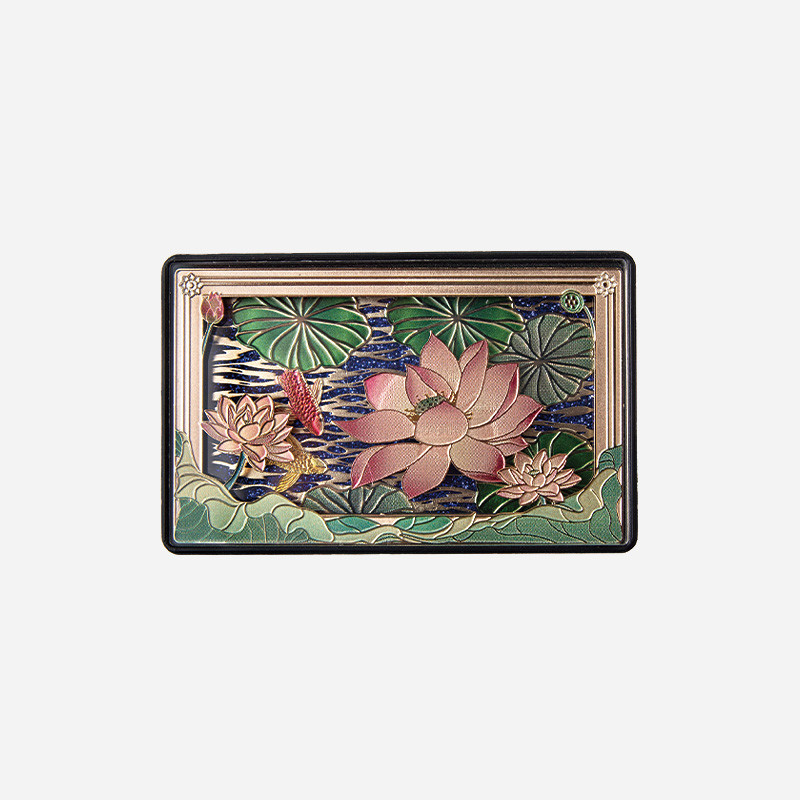 금속 재질 위에 연꽃과 연잎을 입체적으로 양각하고 청록·분홍·금색을 조화시킨 직사각형 마그넷.