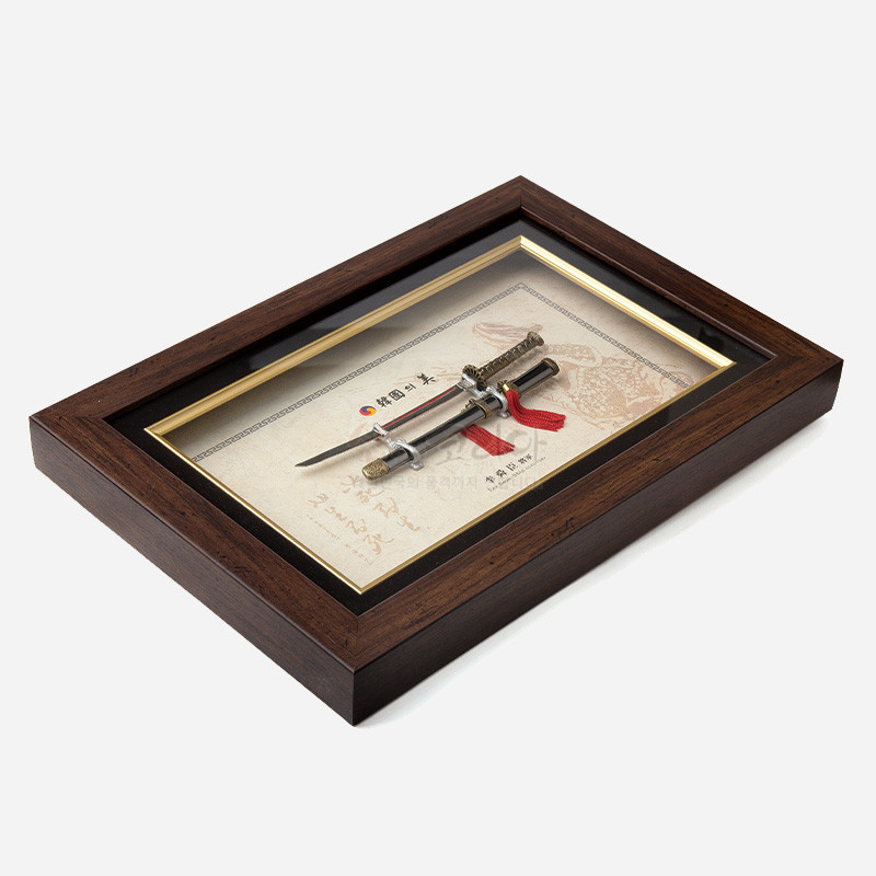 나무 소재 액자에 금속 이순신 장검 미니어처와 붉은 술 장식을 배치한 전통 스타일 장식 액자.