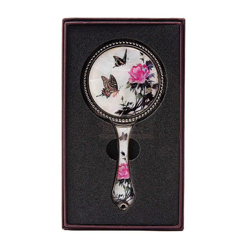 자개 바탕 위에 옻칠로 표현된 담화와 나비 문양, 금속 테두리 장식이 조화로운 손잡이 거울.