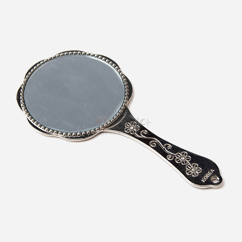 검은색 금속 손잡이에 은색 꽃과 덩굴 문양이 양각된 원형 손잡이 거울.